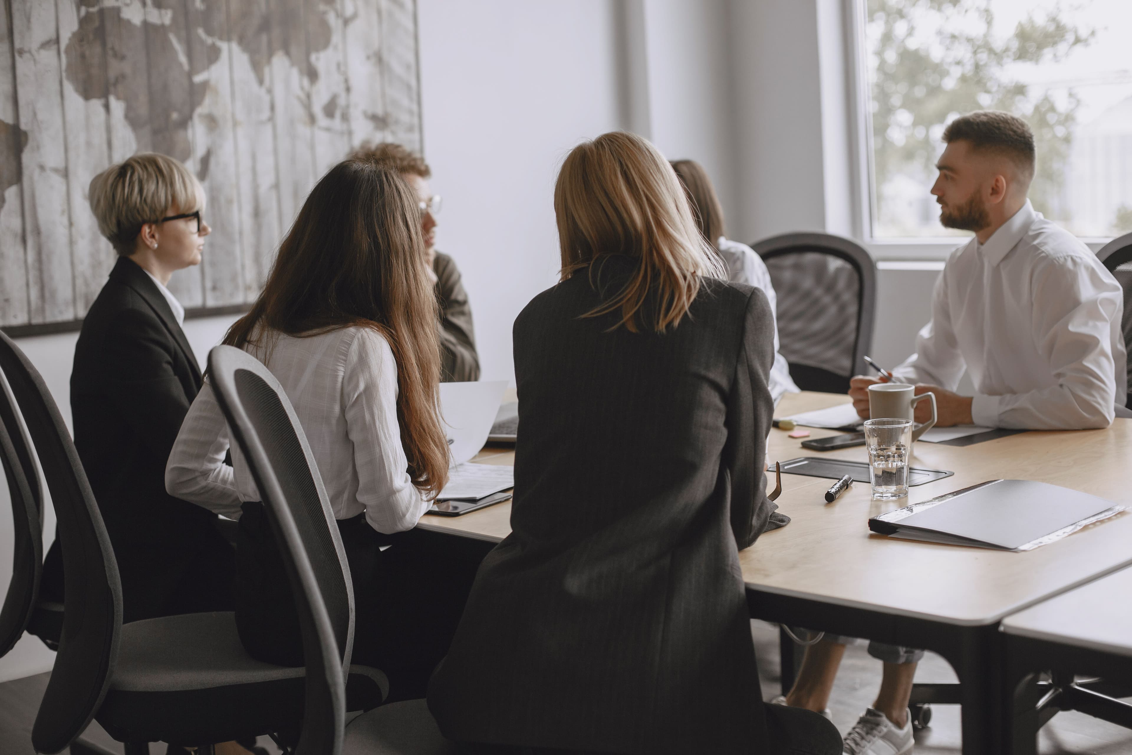 A candidate facing a panel of interviewers across a table in a meeting room