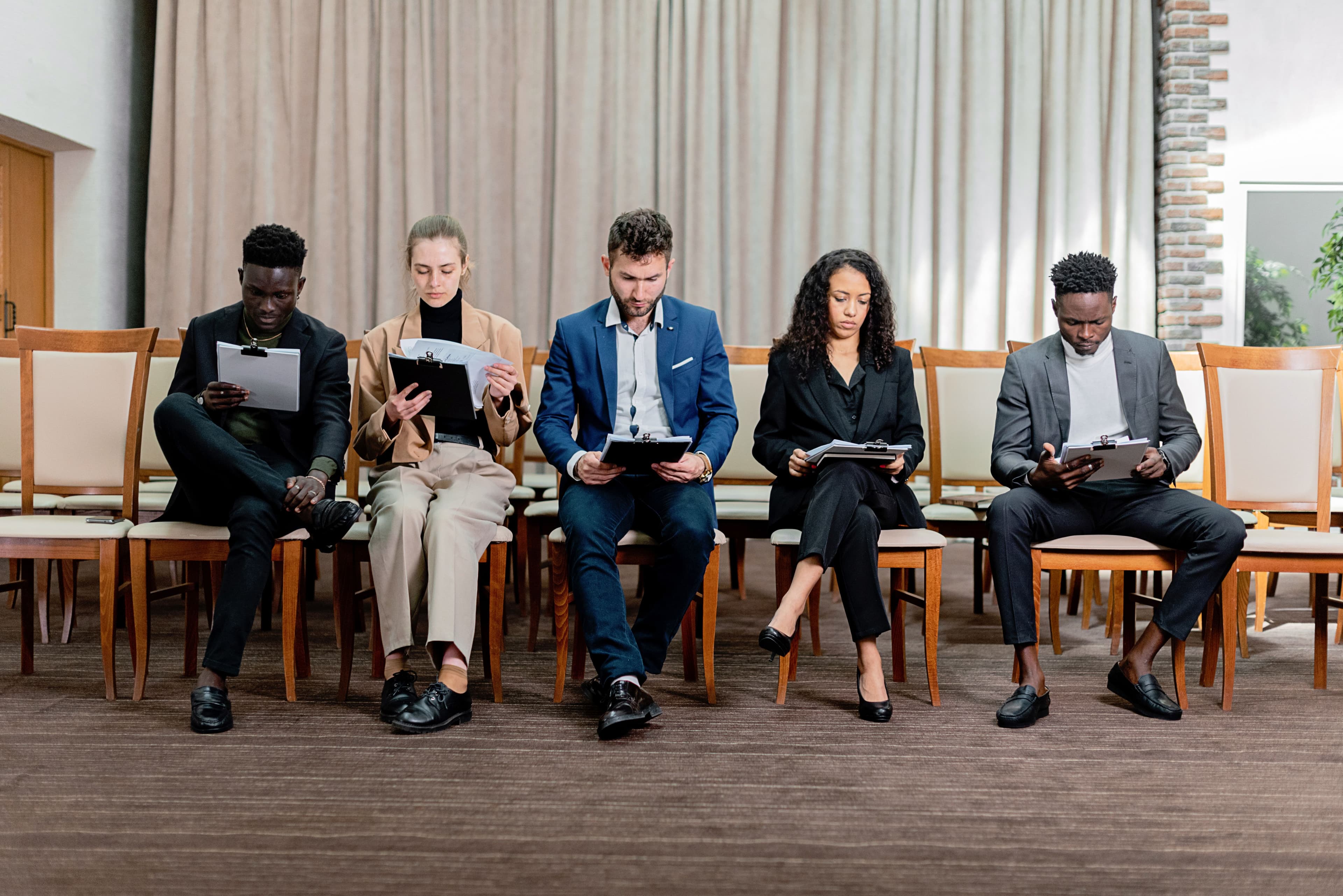 Well-prepared candidates reviewing their notes while waiting for interviews