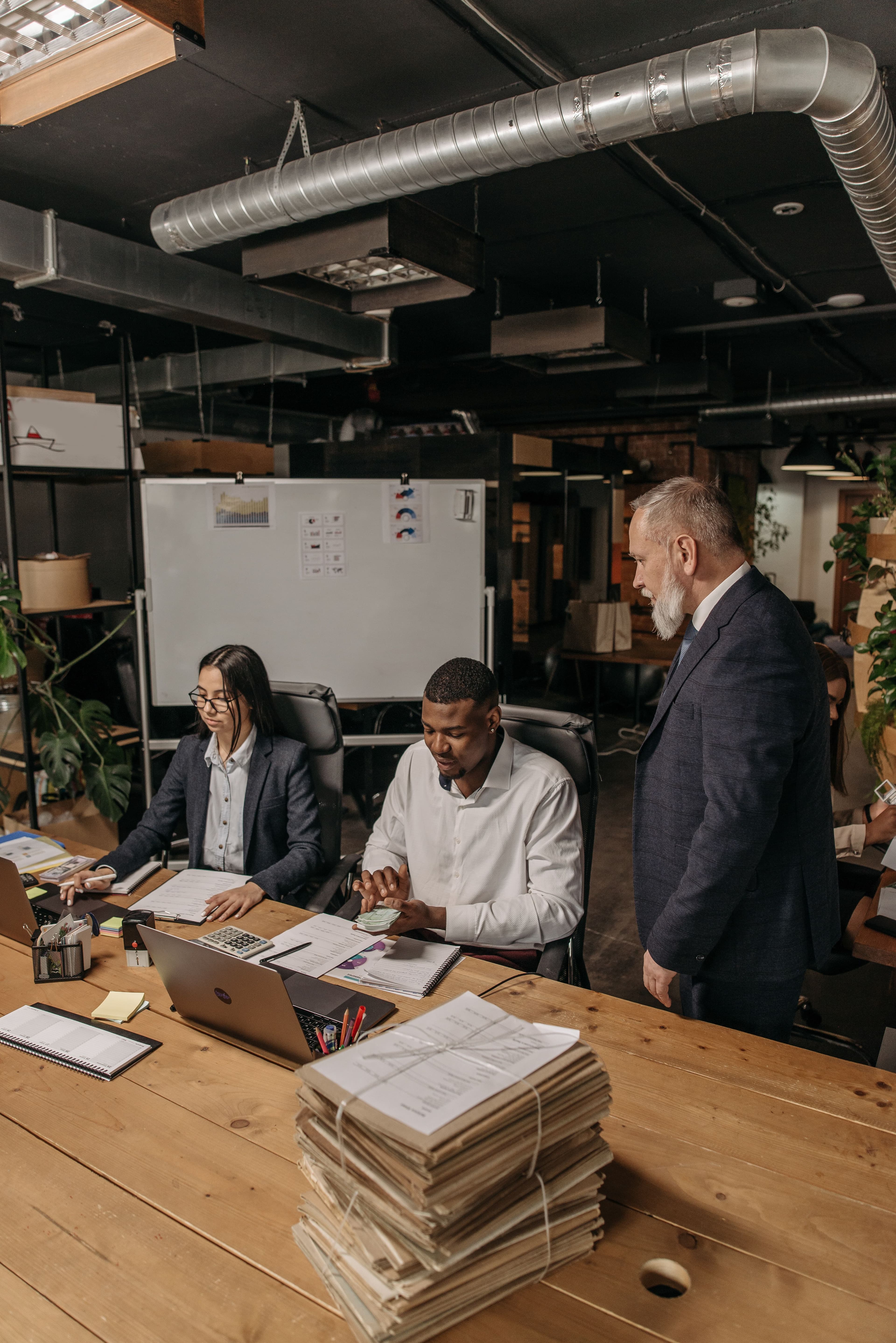 A manager reviewing paperwork and documents with employees in an office