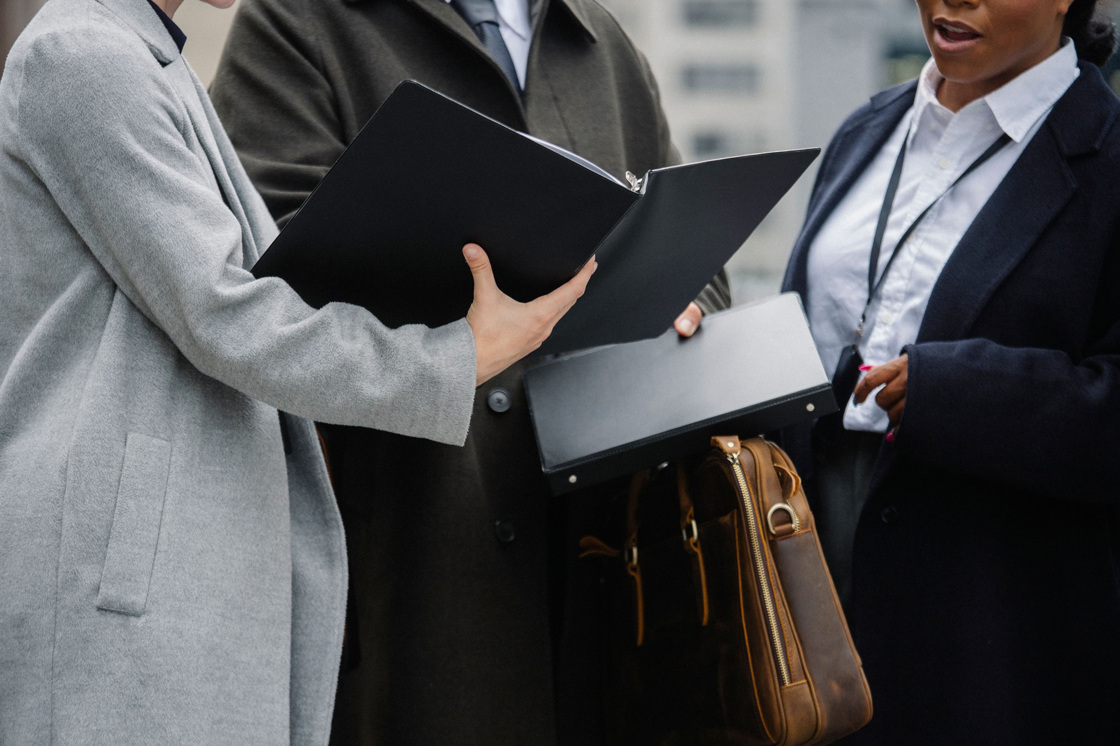 Two professionals reviewing a resume inside an open document folder